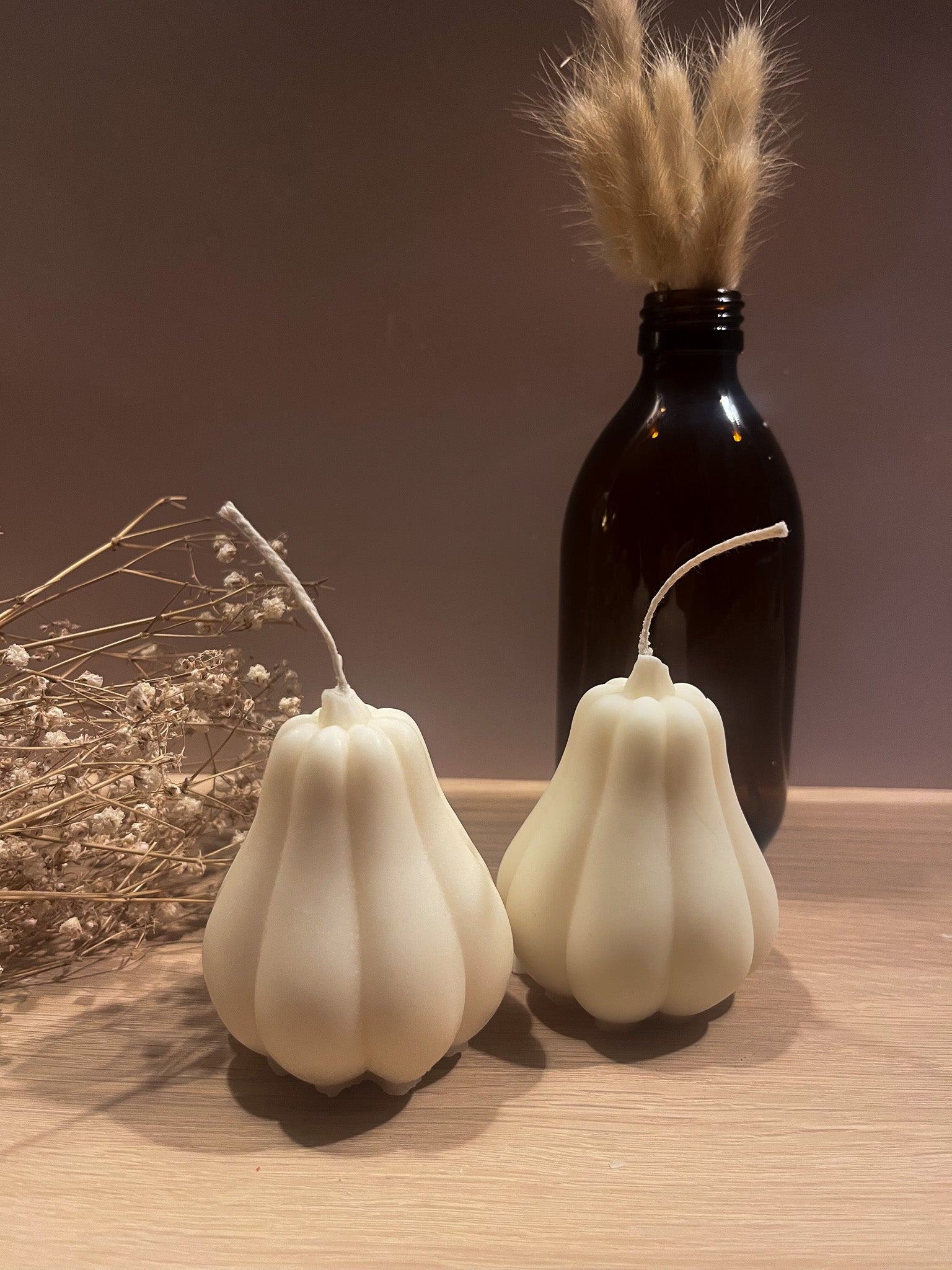 Butternut græskar sojalys med vase i baggrunden. Naturlig og stilren efterårspynt.