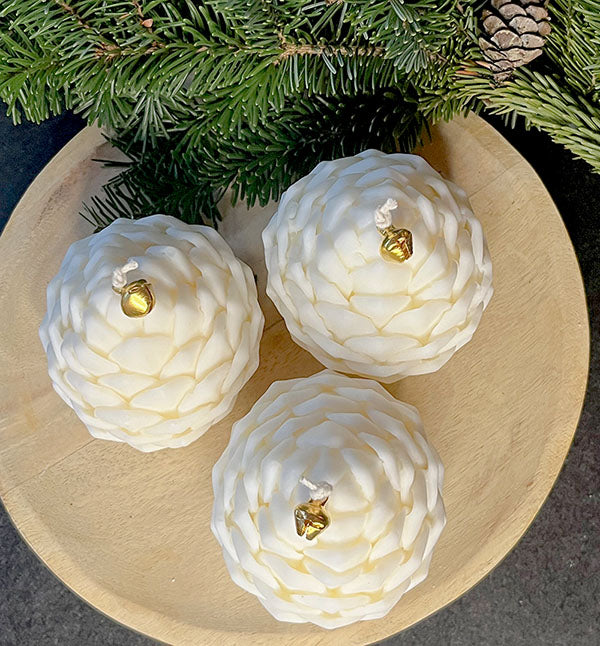 Tre elegante kogle sojalys set oppefra – naturlig og minimalistisk vinterpynt med håndlavet charme.