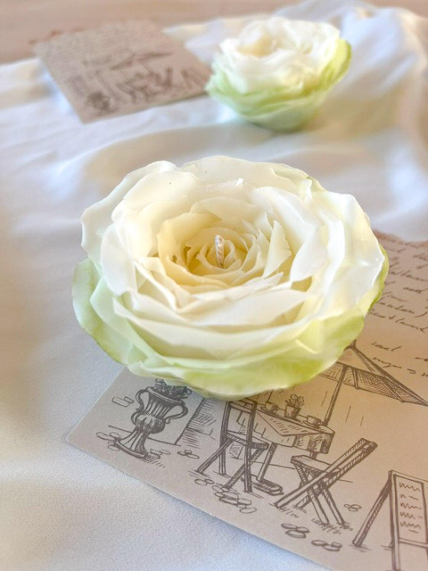 Close up af et håndmodelleret blomsterlys i farven hvid med grønne yderste kronblade.