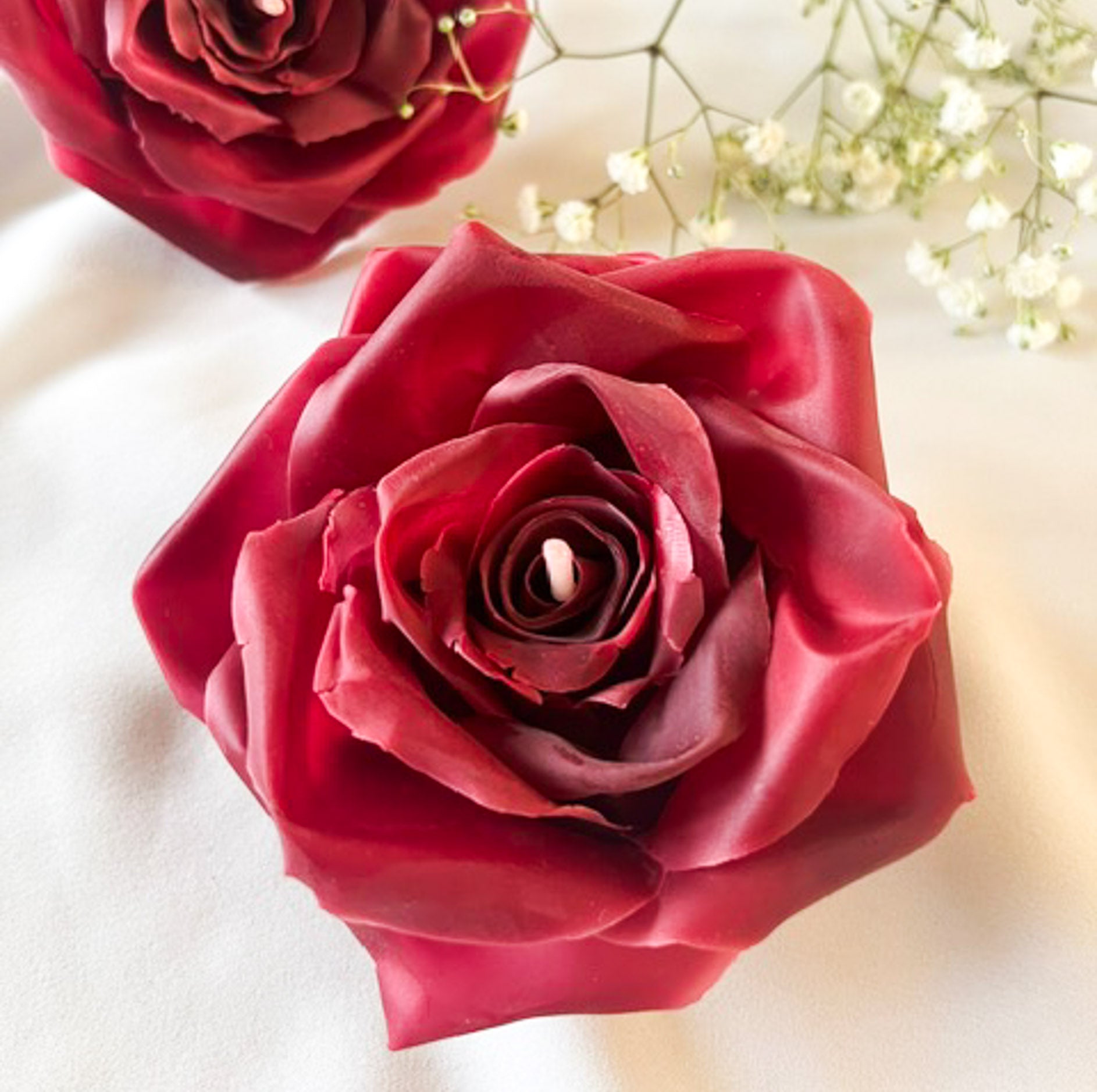 Close op af dyb rød åndmodelleret bivoks der ligner et flot udsprunget rose. Et smukt blomsterlys.